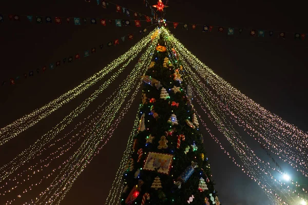 Kerstboom 's nachts versierd met speelgoed en neon lichten — Stockfoto