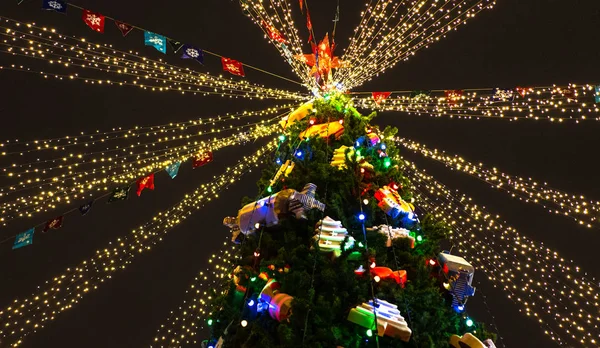 Рождественская елка ночью украшена игрушками и неоновыми огнями — стоковое фото