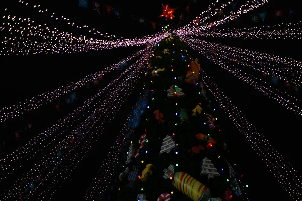 Árvore de Natal à noite decorada com brinquedos e luzes de néon — Fotografia de Stock