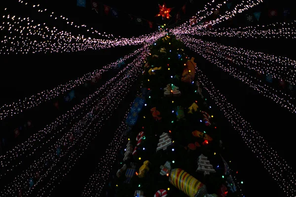 Christmas tree at night decorated with toys and neon lights — Stock Photo, Image