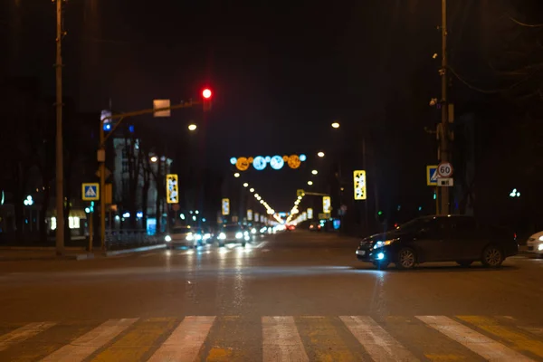 Crossroads at night with a pedestrian crossing, cars and traffic — Stockfoto