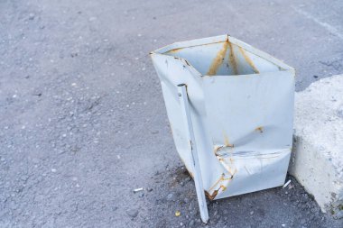 Rumpled metal bucket located on the street