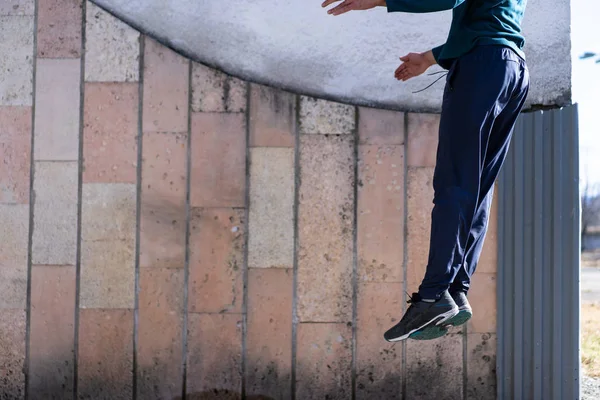 A man jumps high in front of a wall — Stock Photo, Image