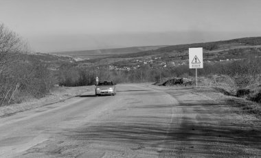 Yolun tehlikeli bir bölümü var. Siyah beyaz fotoğraf.