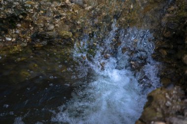 Dağların üzerindeki akarsu temiz bir nehrin üzerinde.