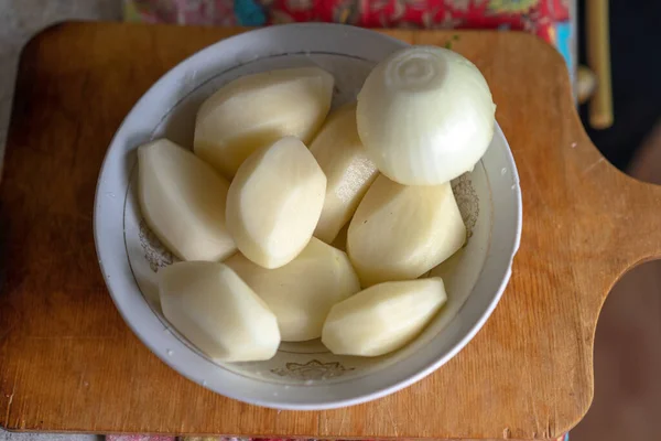 Rohe Geschälte Kartoffeln Und Geschälte Zwiebeln Einem Teller — Stockfoto