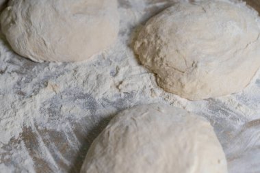 Pişmiş hamur, daha fazla pişirmek için unun üzerinde yatıyor.