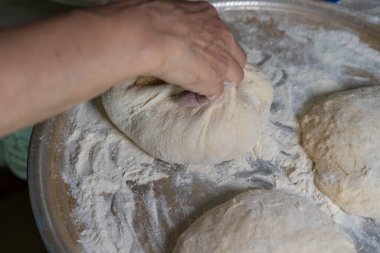 Pişmiş hamur, daha fazla pişirmek için unun üzerinde yatıyor.