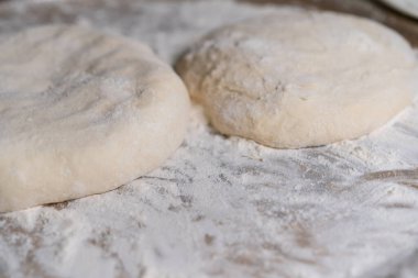 Pişmiş hamur, daha fazla pişirmek için unun üzerinde yatıyor.