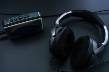 Siyah arka planda kulaklık takan bir kasetçalar.