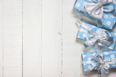 Beyaz ahşap arka planda mavi hediye kutuları
