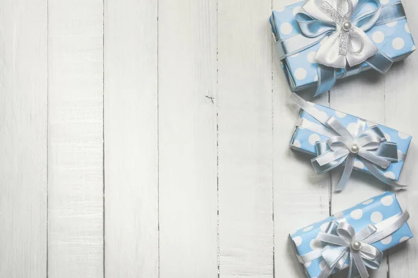 Blue gift boxes on white wooden background