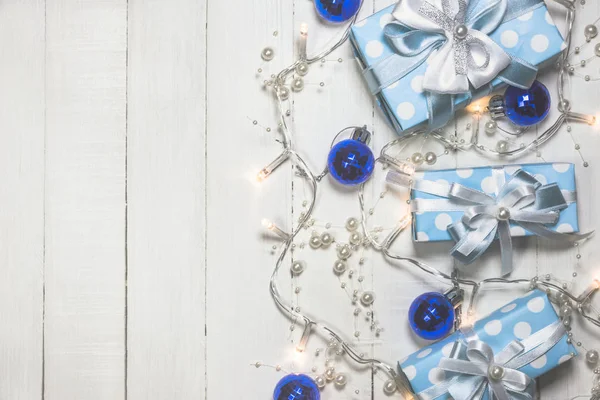 Blue gift boxes and ornaments on white wooden background — Stock Photo, Image