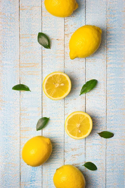 Flad Sammensætning Modne Hele Halve Citroner Med Blade Lyseblå Træ - Stock-foto