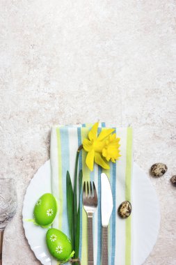 Güzel bir şenlik ya da Paskalya sofrası, bahar çiçekleri ve ışık desenli arka planda yumurtalar. Kopyalama alanı olan üst görünüm.