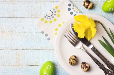 Güzel bir şenlik ya da Paskalya sofrası, bahar çiçekleri ve hafif ahşap arka planda yumurtalar. Kopyalama alanı olan üst görünüm.