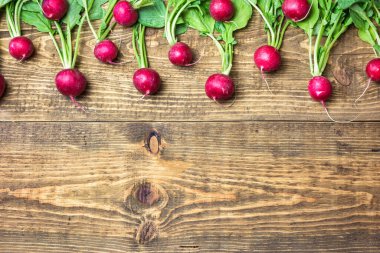 Kırsal ahşap arka planda yeşil yapraklı taze organik kırmızı turplar. Kopyalama alanı olan üst görünüm. Sağlıklı beslenme kavramı.