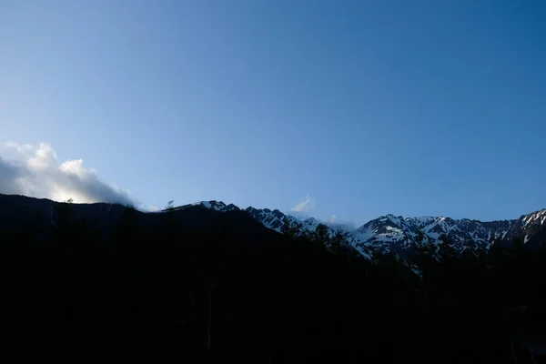 Japonya 'daki Kamikochi Otobüs İstasyonu' ndan gün batımı ve kar dağları manzarası