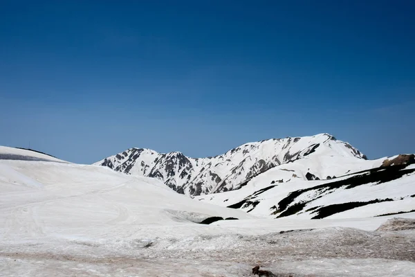 Dağlardaki kar ve Tateyama 'nın Murodo İstasyonu' ndaki mavi gökyüzü manzarası Kurobe Alp Yolu, Japonya Alpleri
