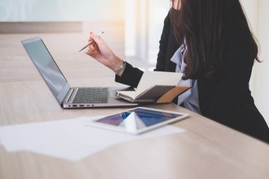 İş kadını ofisteki iş verilerini analiz etmek için bilgisayar ekranını işaret ediyor.