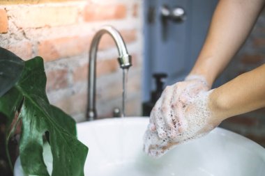 Sabunla birbirine sürterek ellerinizin arkasını sabunla yıkayın. Hijyen konsepti detayı. Coronavirus önleme.