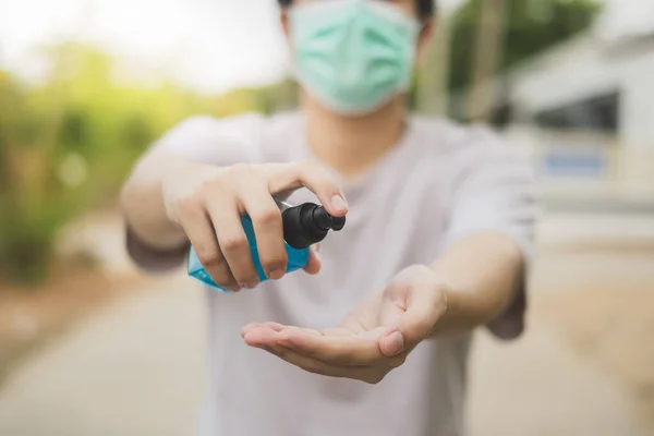 Asyalılar Coronavirus 'u (COVID-19) önlemek için plastik bir şişede alkol jeli kullanıyorlar ve dışarı çıkarken cerrahi maske takıyorlar. Etil alkol el dezenfektanı, Coronavirüs 'ü dezenfekte etmeye yardımcı olur..