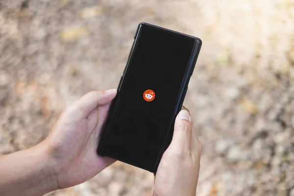 RAYYONG, THAILAND, APR 12.2020: Samsung Galaxy Note akıllı telefonunda Reddit Uygulaması kullanan bir adam. Reddit bir haber paylaşımı, tartışma ve web içeriği Amerikan web sitesidir..