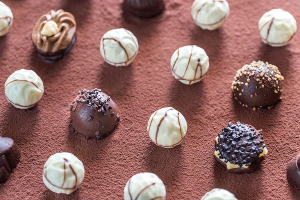 Cukierki czekoladowe na tle kakao — Zdjęcie stockowe