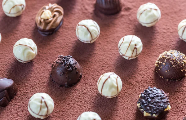 ココアの背景の上にチョコレート菓子 — ストック写真