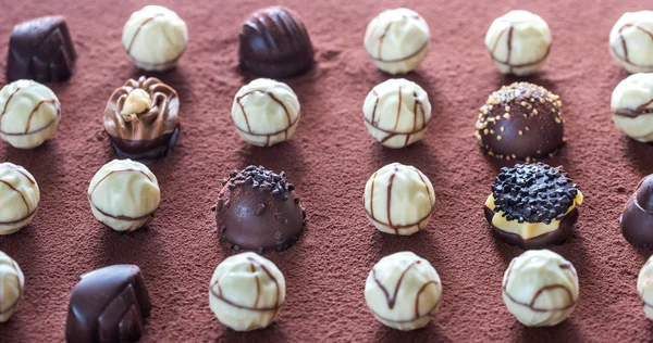 Bonbons au chocolat sur fond de cacao — Photo