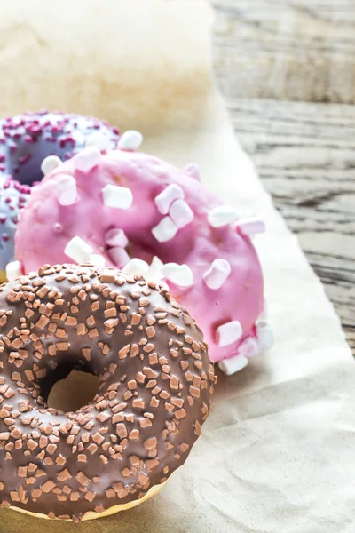 Rosquillas de colores en el papel para hornear — Foto de Stock