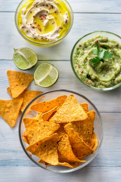 Miski, hummus i guacamole z chipsy tortilla — Zdjęcie stockowe