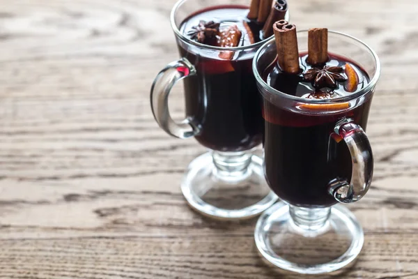 Dois copos de vinho quente no fundo de madeira — Fotografia de Stock