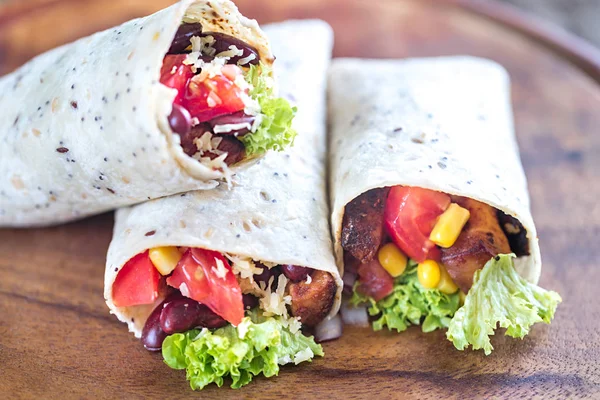 Three chicken burritos on the wooden board — Stock Photo, Image