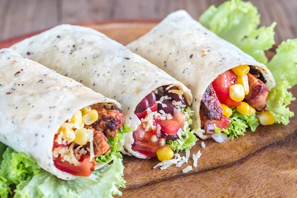 Three chicken burritos on the wooden board — Stock Photo, Image