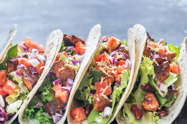 Four mexican tacos on a black background — Stock Photo, Image