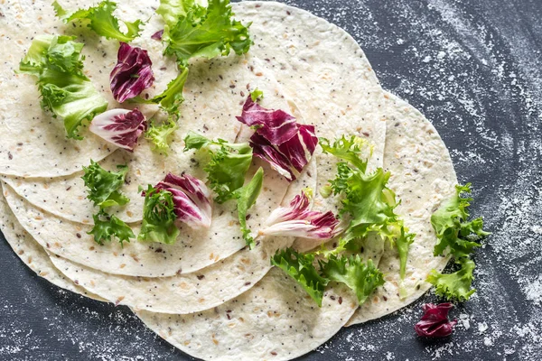 Tortillas with lettuce on a black surface — Stock Photo, Image