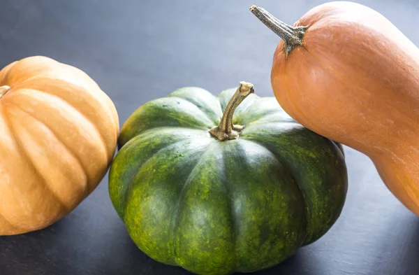 Trois citrouilles sur le fond en bois sombre — Photo