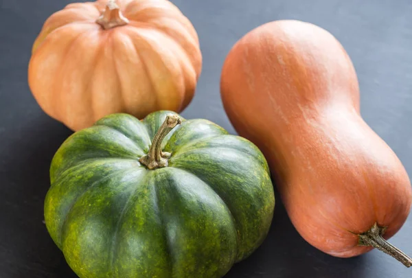 Tres calabazas sobre el fondo de madera oscura —  Fotos de Stock