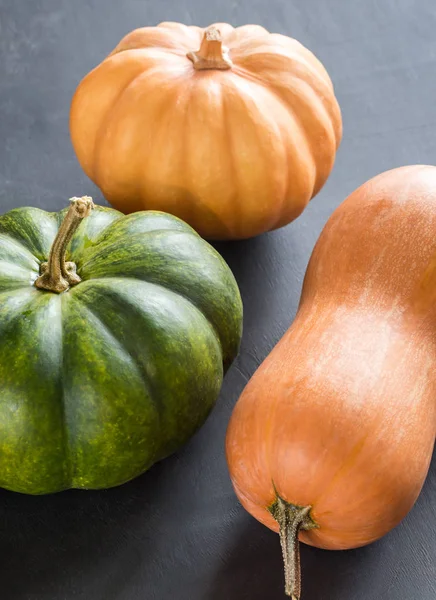 Tres calabazas sobre el fondo de madera oscura —  Fotos de Stock