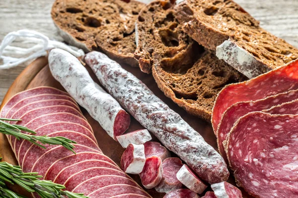 Different kinds of salami with dark-rye bread — Stock Photo, Image