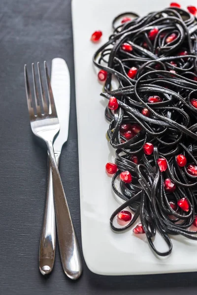 Black pasta with pomegranate seeds — Stock Photo, Image