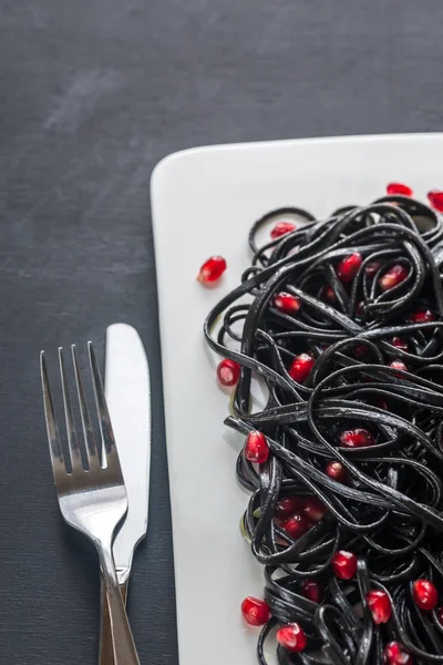 Black pasta with pomegranate seeds — Stock Photo, Image