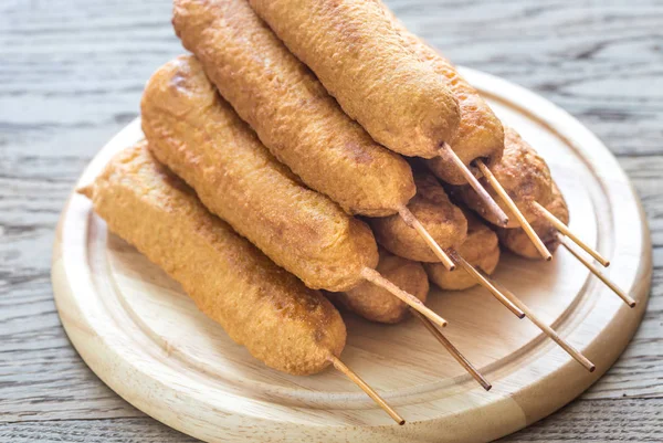 Stack of corn dogs on the wooden board — Stock Photo, Image