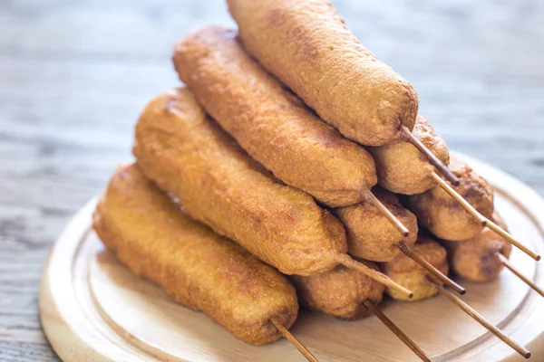 Stack of corn dogs on the wooden board — Stock Photo, Image