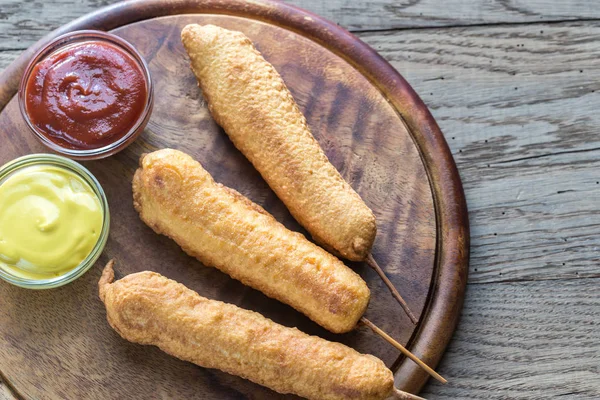 Stack of corn dogs on the wooden board — Stock Photo, Image