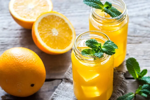 Glass jars of orange juice — Stock Photo, Image