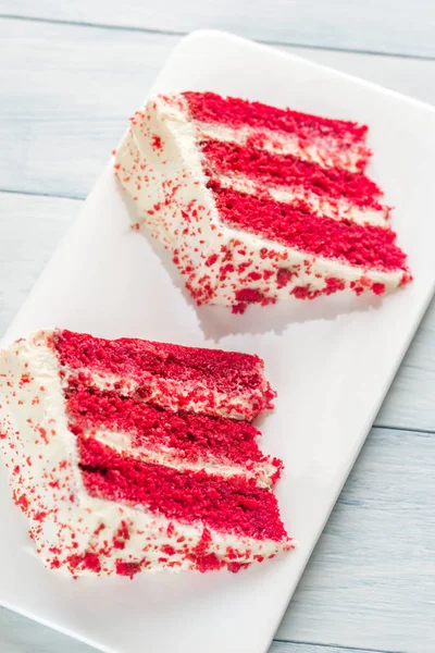 Два ломтика красного бархатного торта на белой тарелке — стоковое фото