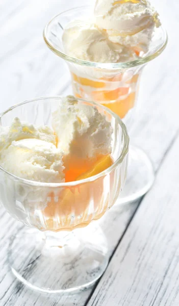 Dos tazones de helado de vainilla con duraznos —  Fotos de Stock
