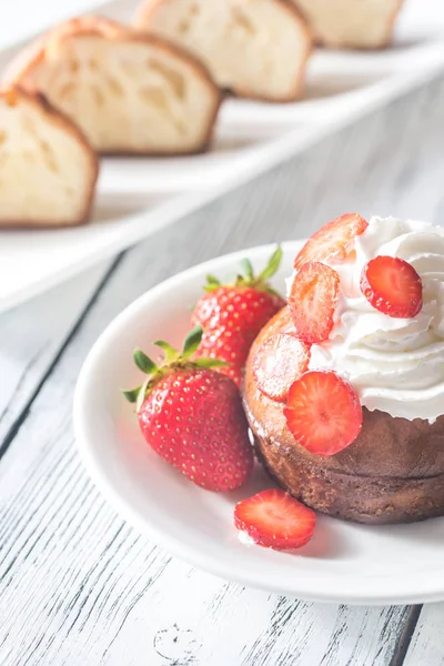 Rum baba decorato con panna montata e fragole fresche — Foto Stock